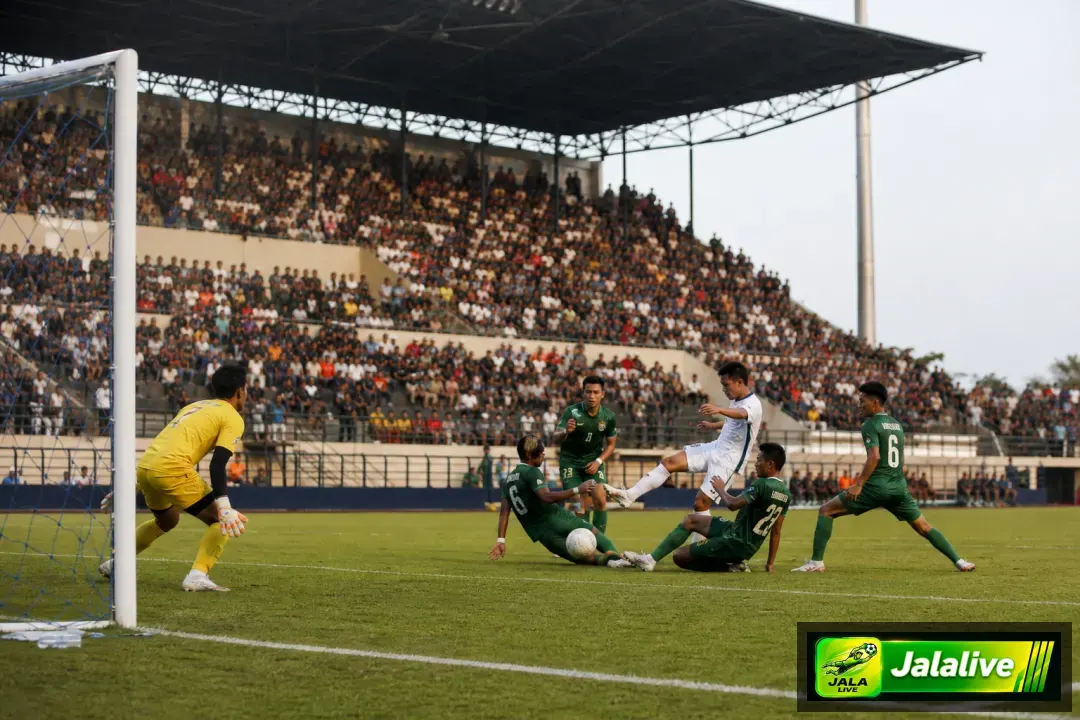 Pemain sepak bola dan penjaga gawang dalam pertandingan di stadion Indonesia