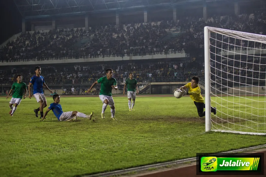 Pemain sepak bola Liga 1 Indonesia dan kiper saat momen penyelamatan di stadion