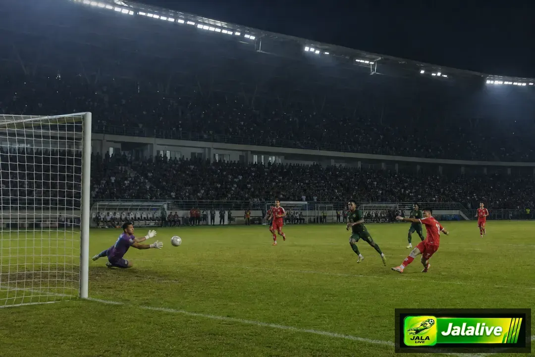 Penjaga gawang melakukan penyelamatan dalam pertandingan sepak bola di Indonesia